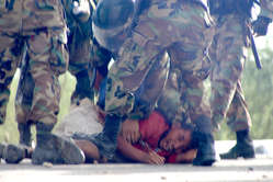 A wounded protester is beaten by police, Bagua, Peru