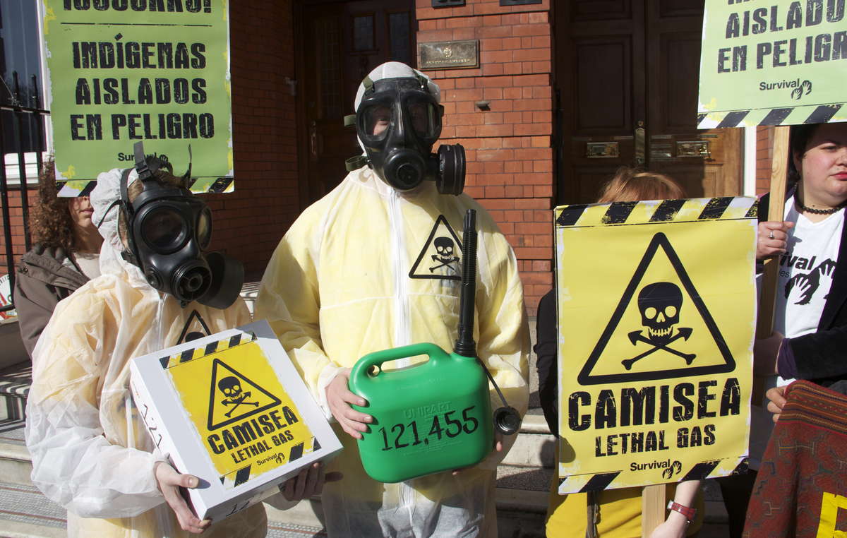 Des manifestants à Londres portant des masques à gaz et brandissant des pancartes pour symboliser les effets mortels du projet Camisea sur les Indiens isolés du Pérou.