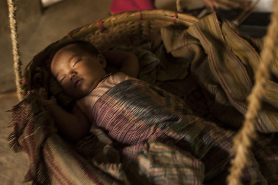 A Chakma mother in Bangladesh places her newborn child in a traditional cot called a _dhulon_, and sings them to sleep with lullabies known as _olee daagaanaa_.

Since Bangladesh became independent from Pakistan in 1971, the indigenous Jumma people of the Chittagong Hill Tracts in the mountainous south-east region have endured some of the worst human rights violations in Asia. 

Gentle, compassionate and religiously tolerant, the Jumma differ ethnically and linguistically from the Bengali majority. 
