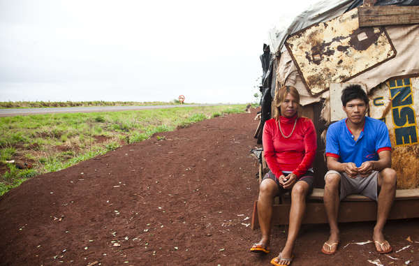 Ένα ζευγάρι Guaranu-Kaiowa κάθεται έξω από τον αυτοσχέδιο οδικό άξονα της κοινότητας Apy Ka'y, κοντά στον Dourados, Mato Grosso do Sul της Βραζιλίας.