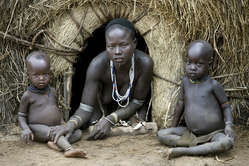 Les Karo (ou Kara), qui représentent une population de plus d’un millier de personnes vivent sur les rives orientales de la rivière Omo, en Ethiopie du Sud. Ici, une mère Karo est assise avec ses enfants.