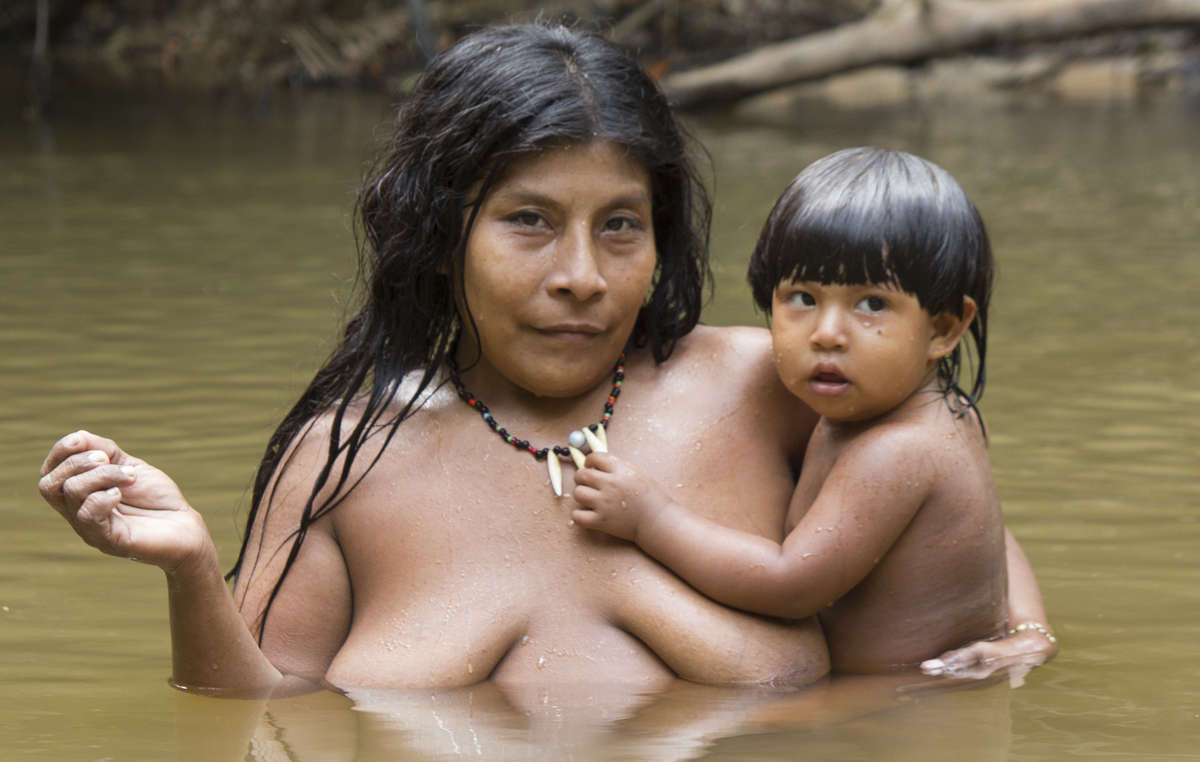 Eine Mutter und ein Kind baden in einem Bach in der Nähe ihrer Gemeinde. Was auch immer unsere Unterschiede sind, die Sprache zeigt, dass Eltern überall auf ähnliche Weise mit ihren Kindern verbunden sind.