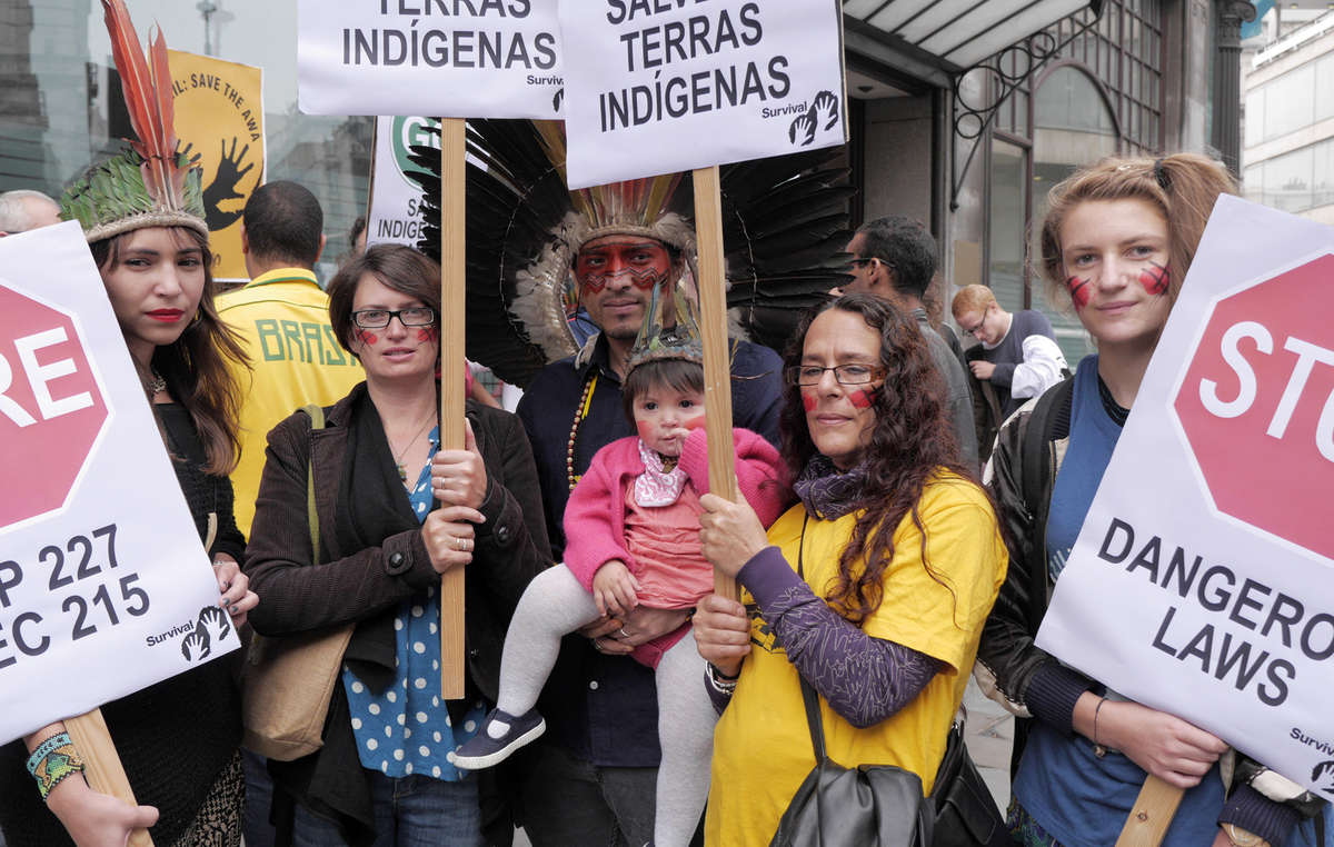 Protestors held placards telling Brazil to stop dangerous laws and save Indigenous lands.