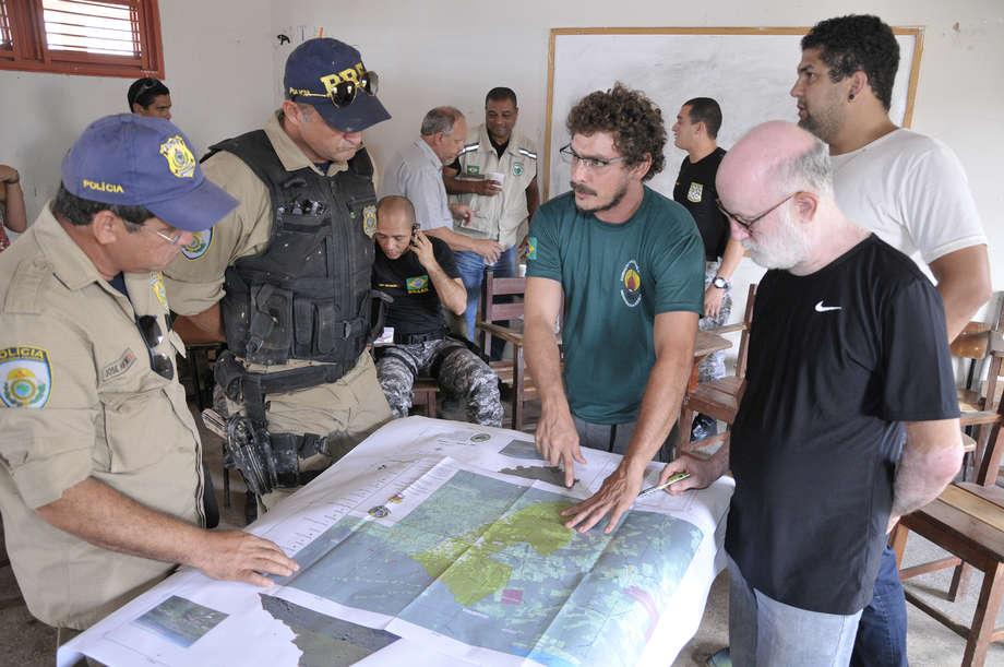 Carlos Travassos, head of FUNAI's Uncontacted and Recently Contacted Indians Department (centre), shows Federal police a map of the Awá's territory.
