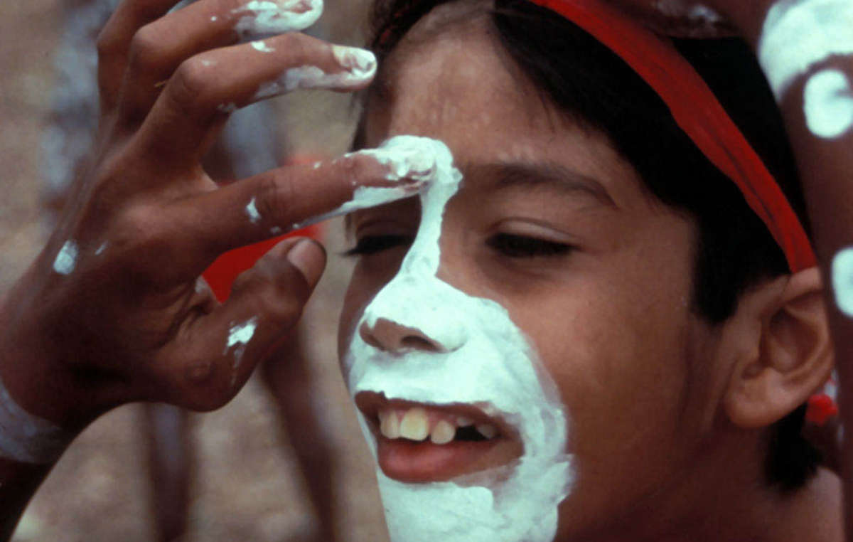 An Aboriginal child is being painted for a dance festival in Northern Queensland, Australia.