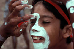An Aboriginal child is being painted for a dance festival in Northern Queensland, Australia.