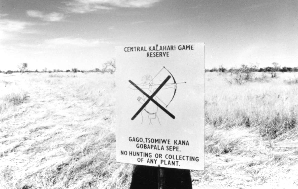 Cartel situado en la entrada de la Reserva de Caza del Kalahari Central que prohíbe a los bosquimanos cazar. Botsuana, 1989.