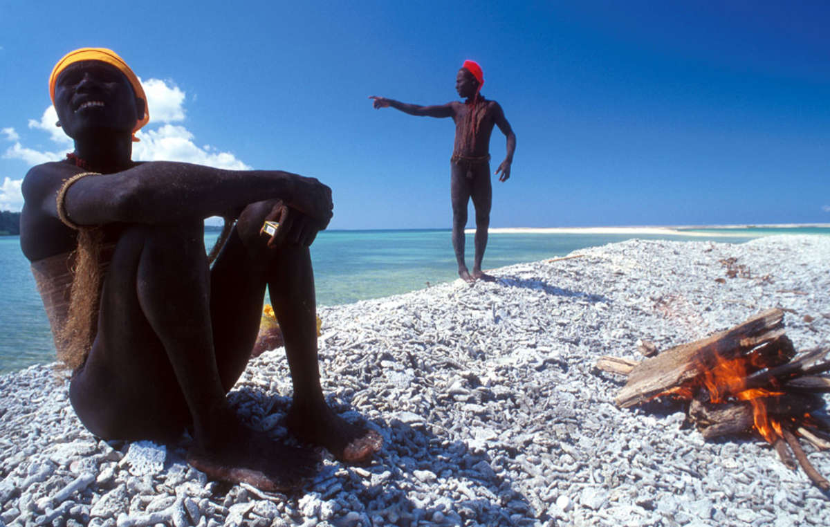 Two Jarawa relax by the coast of the Andaman Islands.