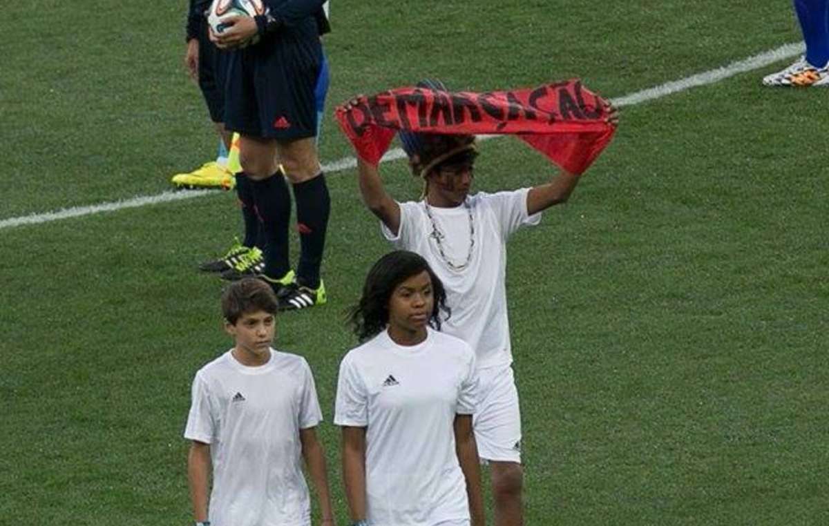 Ein Guarani-Junge protestierte bei der Eröffnungsfeier der Fußball-WM mit einem Banner, auf dem zu lesen war: 'Demarkierung jetzt!'