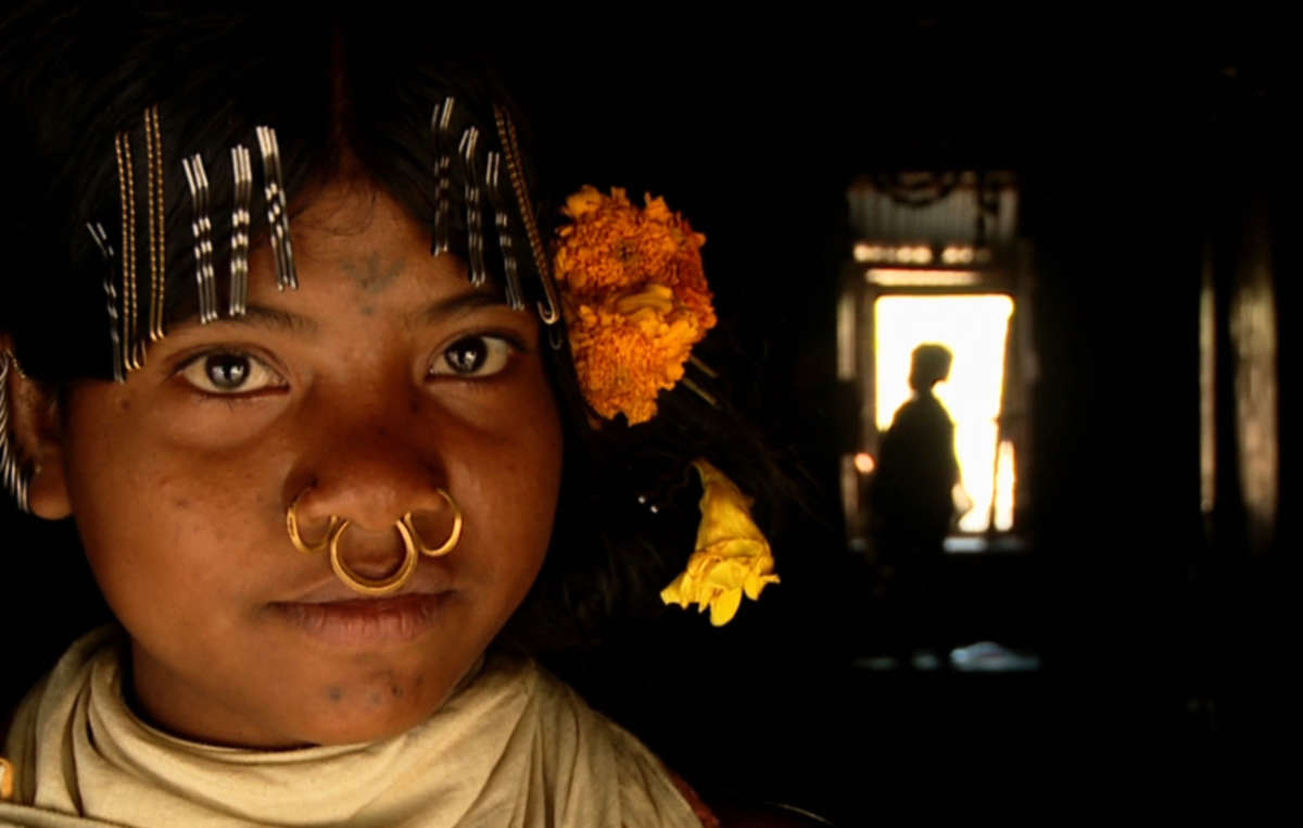 Mitu, a Dongria Kondh girl, outside her house in Orissa, India.